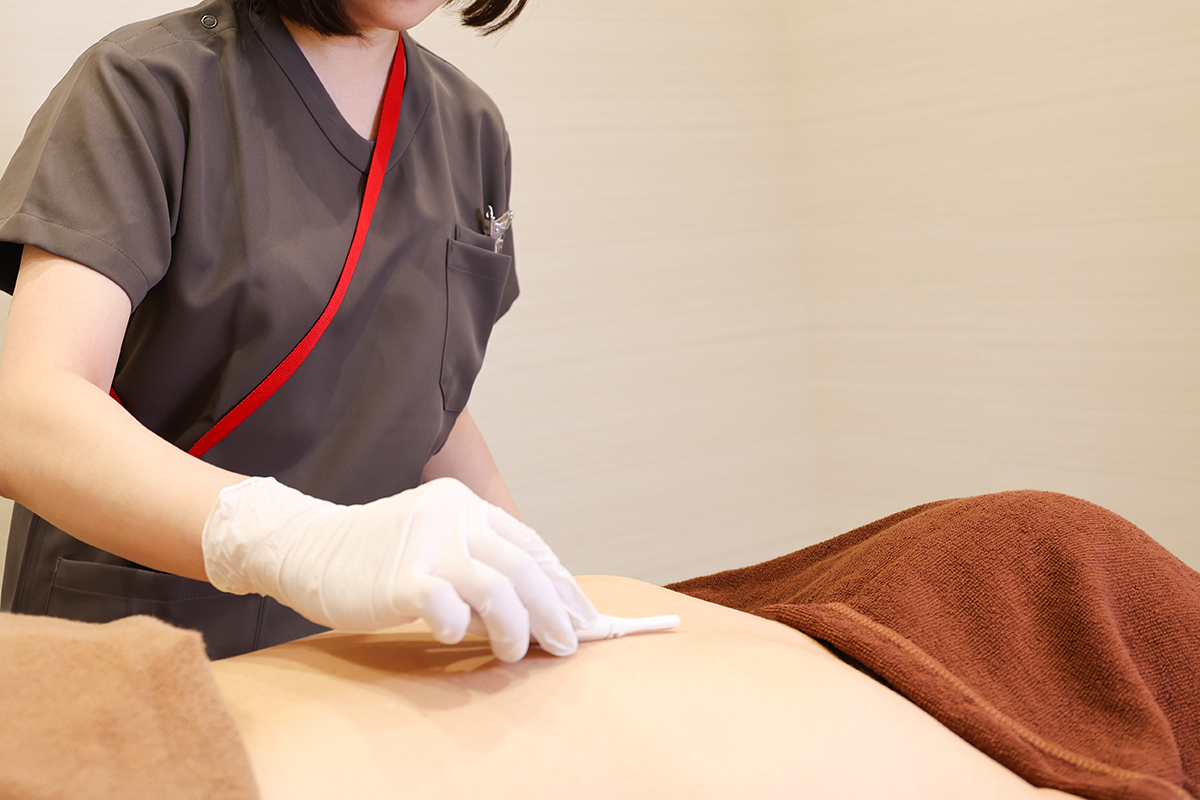 脱毛施術前に看護師が背中の剃毛をする様子